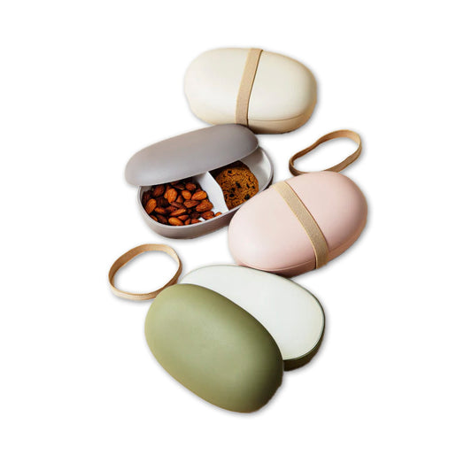 Set of four small, round, color-blocked oval containers with lids on a white background. view 1