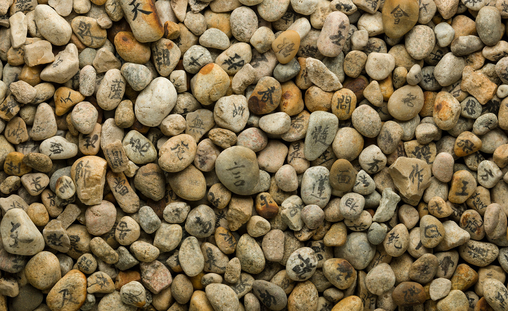 Large array of stones with Japanese characters painted on them.